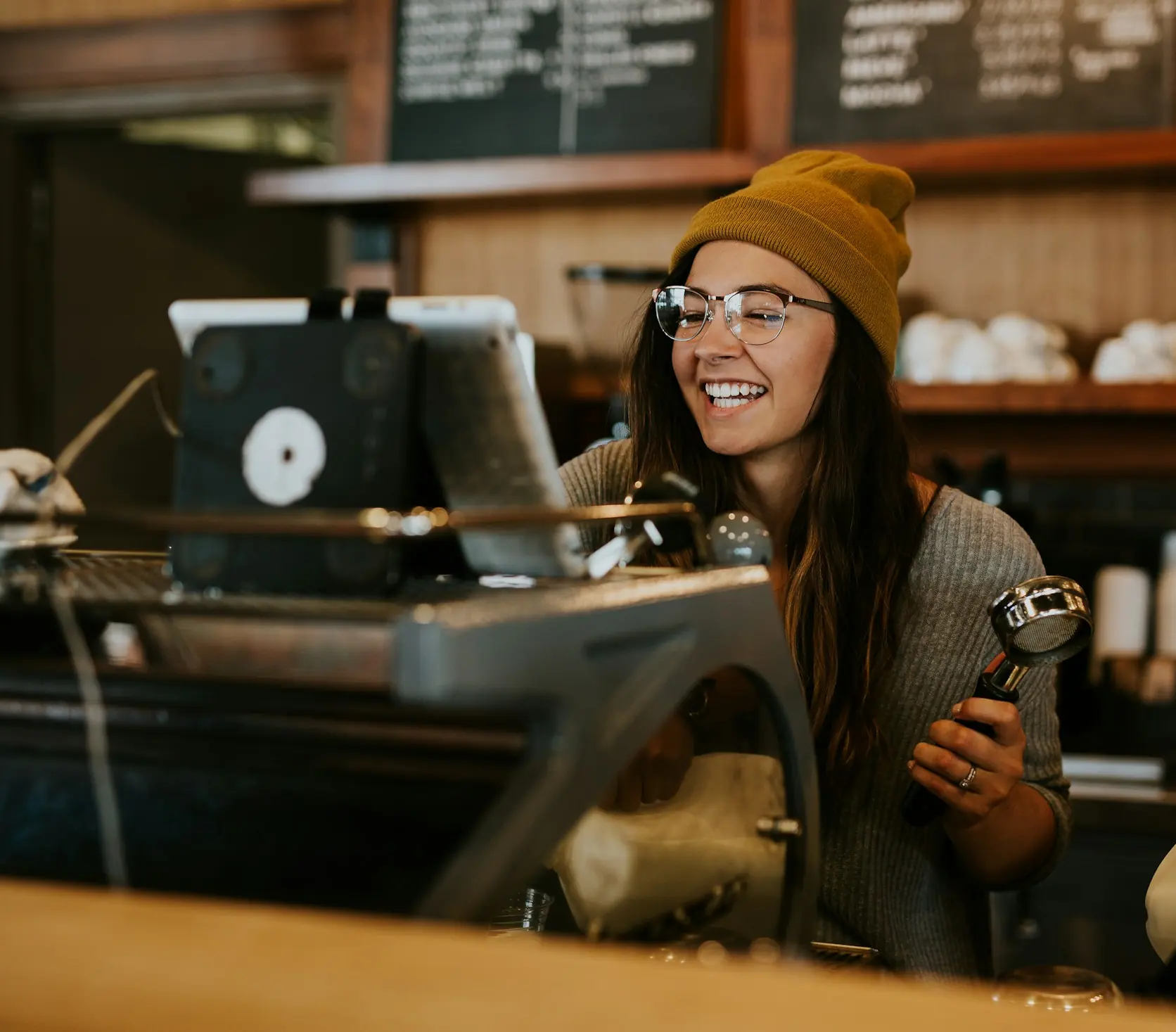Barista sorrindo atrás do balcão de um café