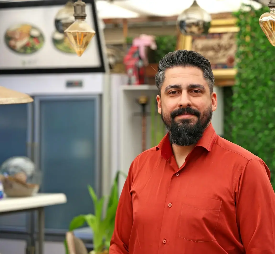 Dono de restaurante sorrindo no salão